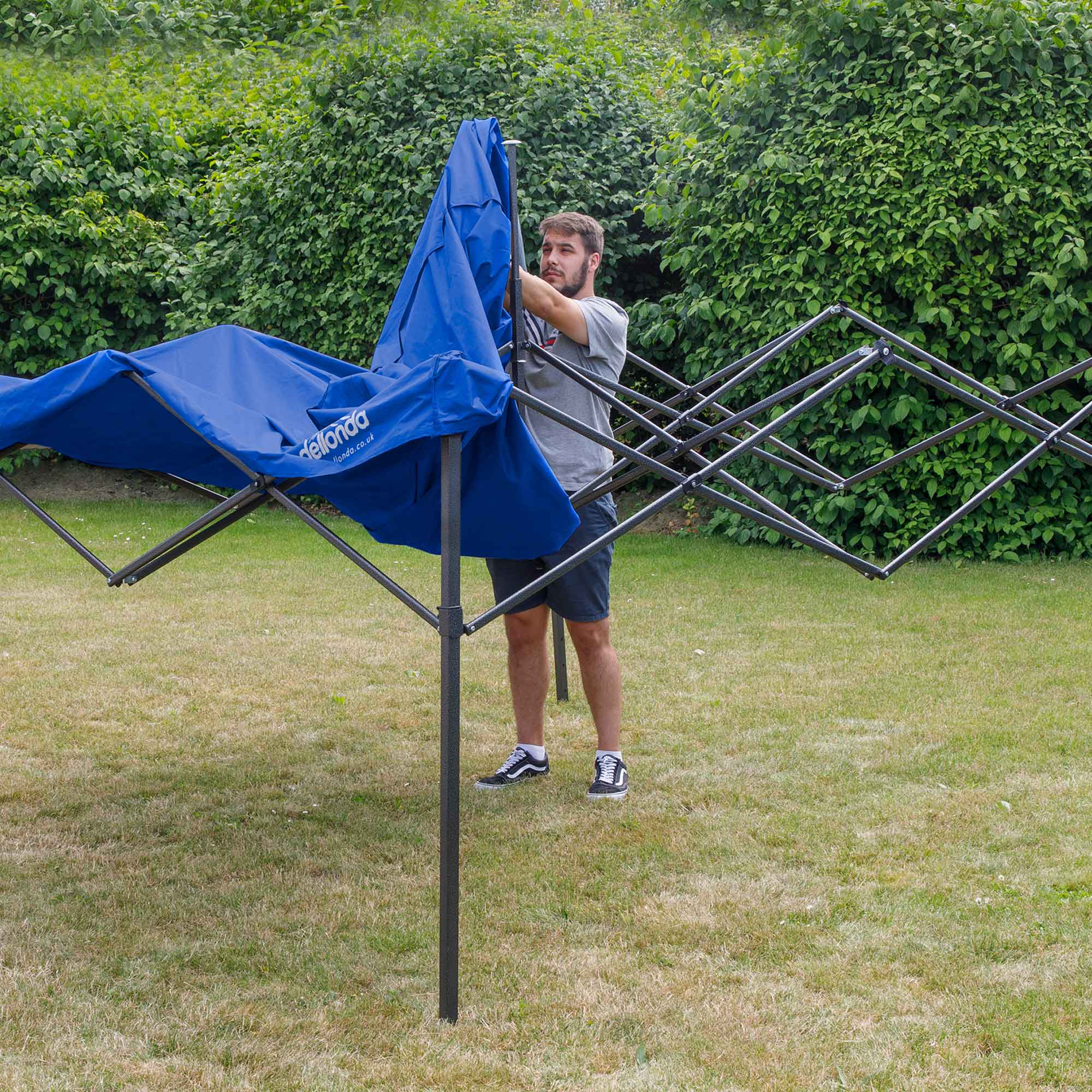 Dellonda DG127 Gazebos Action shot - putting - cover - over