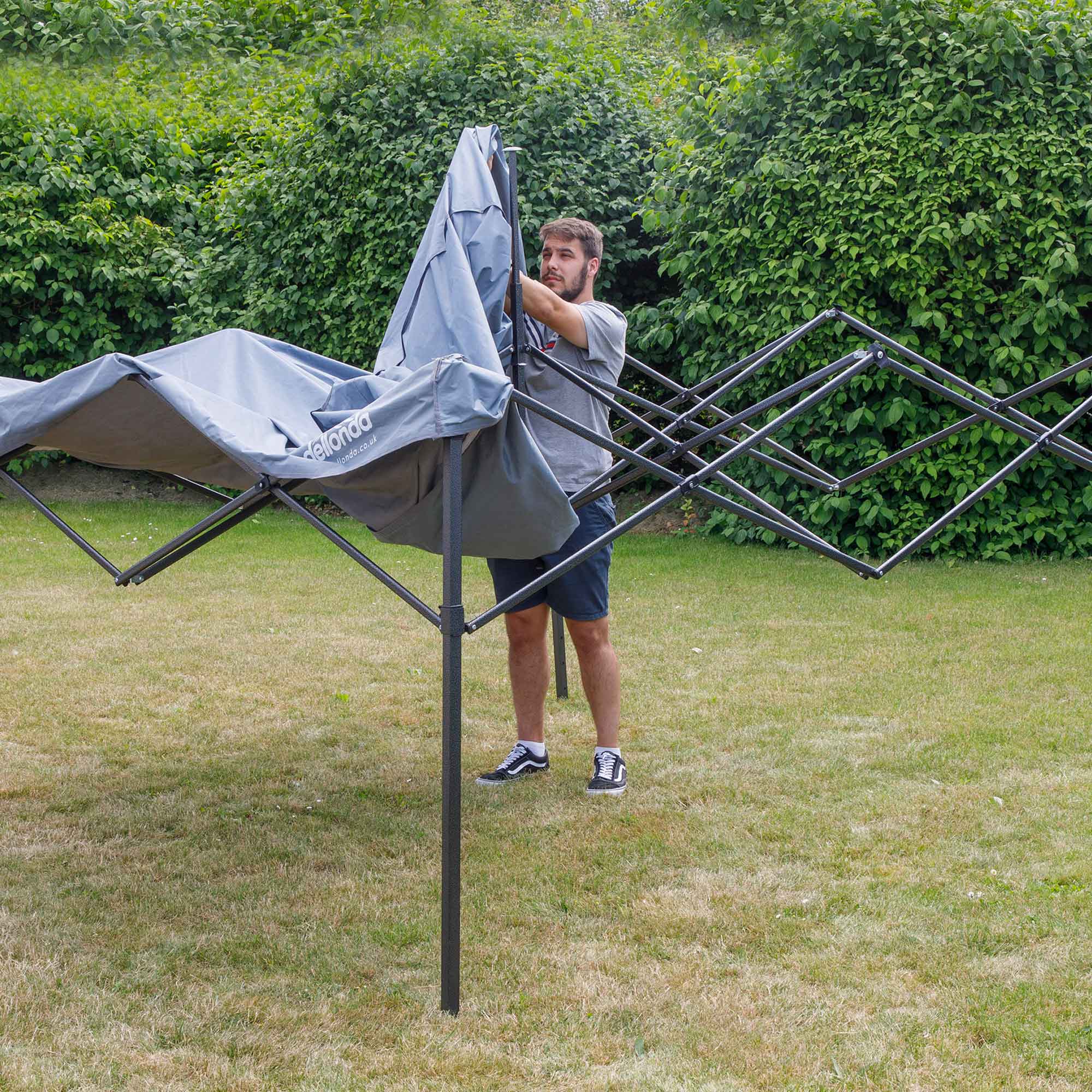 Dellonda DG129 Gazebos Action shot - putting - cover - over